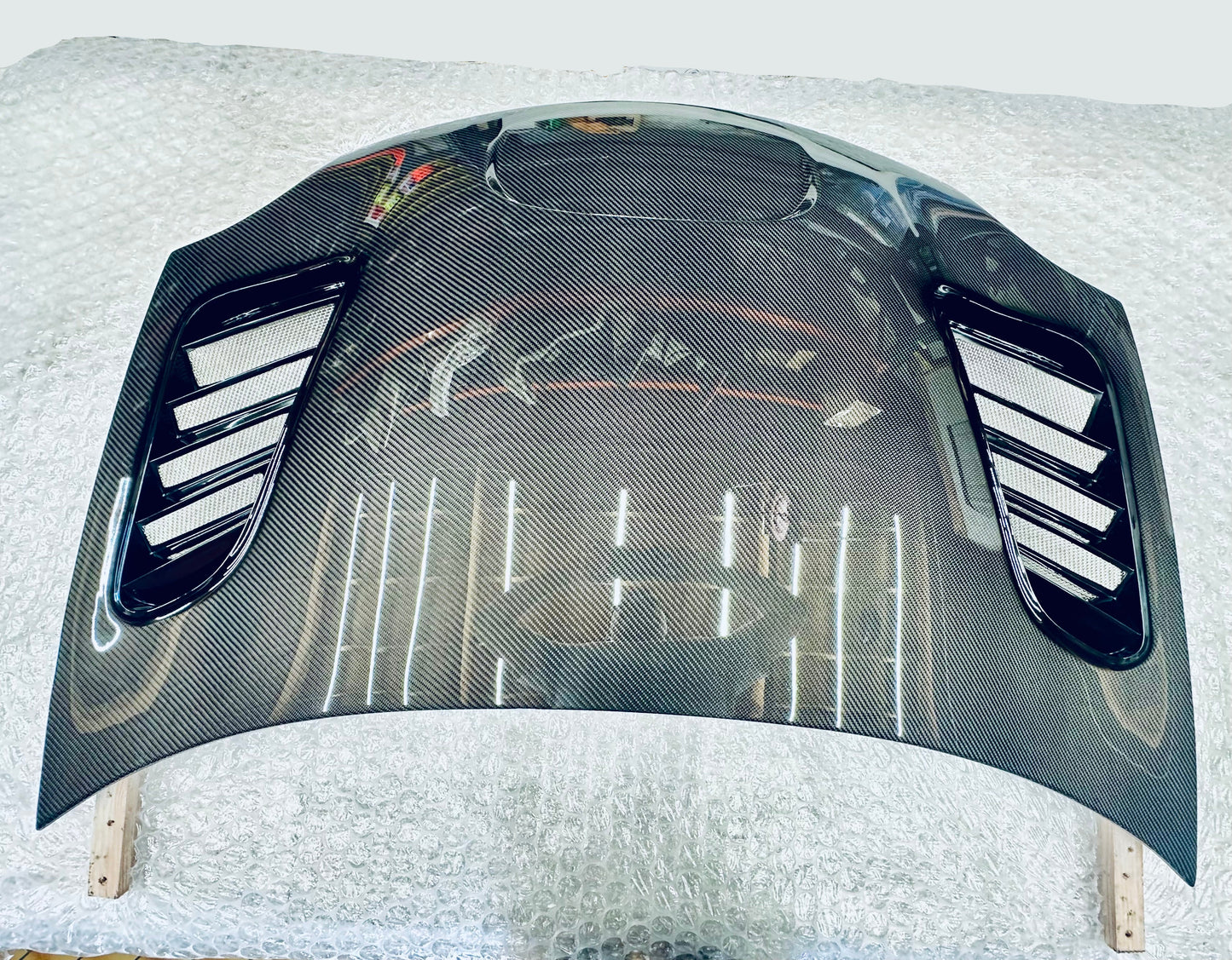2003-2005 dodge neon srt-4 Carbon fiber hood on a white surface with a blurred background