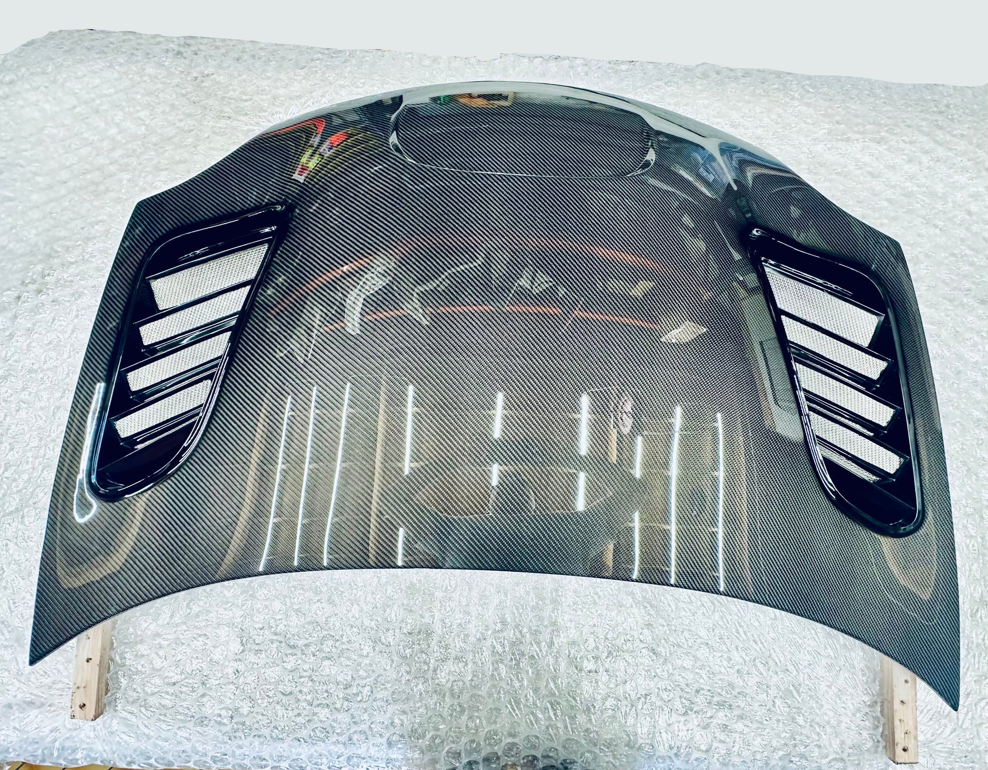 2003-2005 dodge neon srt-4 Carbon fiber hood on a white surface with a blurred background