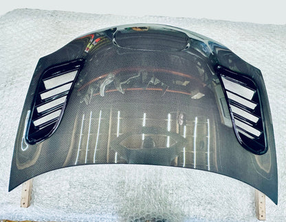 2003-2005 dodge neon srt-4 Carbon fiber hood on a white surface with a blurred background
