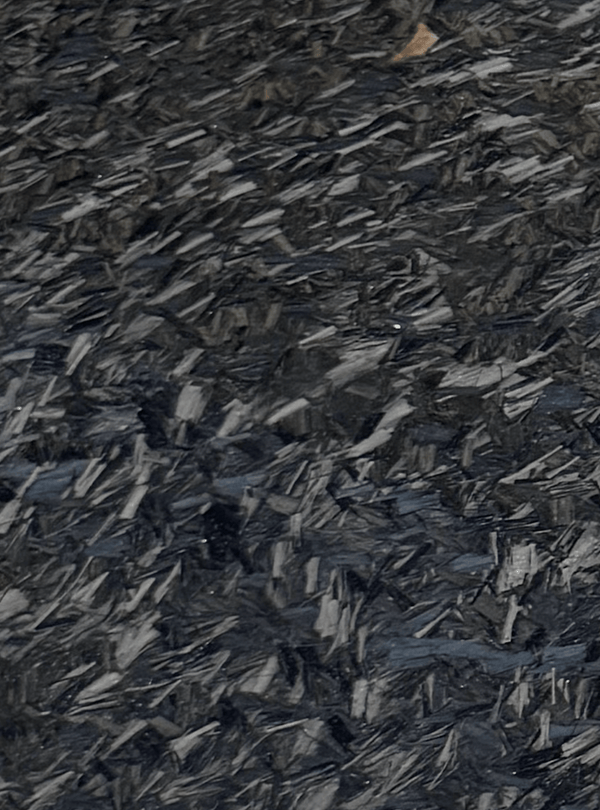 Close-up of forged carbon fiber material texture featuring a distinctive chopped carbon pattern and glossy finish