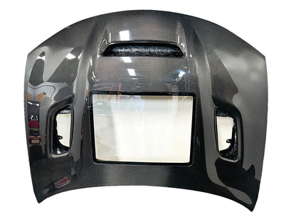 Carbon fiber hood for a Dodge Charger vehicle, featuring a glossy black finish and ventilation slots top view