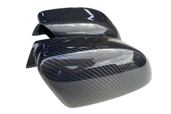 Handcrafted carbon fiber side mirror covers for Dodge Charger and Chrysler 300, showing curved contours and glossy twill weave finish.
