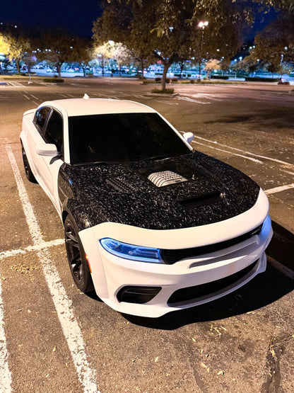 White car with forged carbon fiber fneders in a parking lot at night